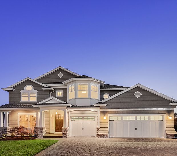 Modern house with illuminated windows at dusk.