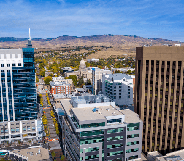 Cityscape with mountains and blue sky background.